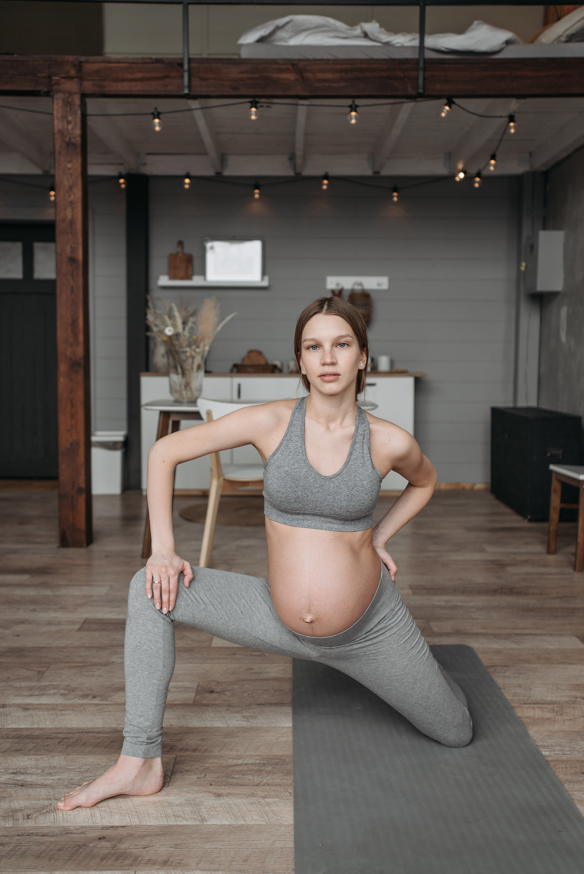 A Pregnant Woman in Gray Activewear Exercising at Home